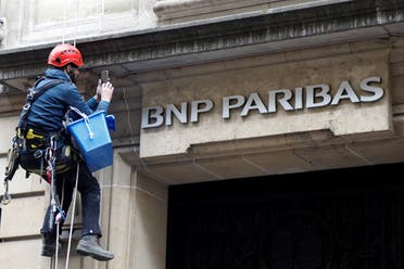 A worker cleans up the facade of a BNP Paribas bank office in Paris. (Reuters)
