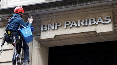 A worker cleans up the facade of a BNP Paribas bank office in Paris. (Reuters)