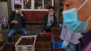(FILES) In this file photo taken on April 15, 2020, vendors wearing face masks sell prawns at the Wuhan Baishazhou Market in Wuhan in China's central Hubei province. US President Donald Trump's administration is urging an investigation into the origins of the coronavirus pandemic, saying it doesn't rule out that it came from a laboratory researching bats in Wuhan, China. Beijing has said that the virus, which has killed more than 138,700 people worldwide, was likely transmitted to humans late last year at a Wuhan wet market that butchered exotic animals -- a longtime focus of concern for public health experts.