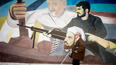 A blind man walks past a mural on a wall at Palestine Square in Tehran March 4, 2007. (Reuters)