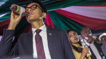 Madagascar's President Andry Rajoelina drinks a sample of the Covid Organics or CVO remedy at a launch ceremony in Antananarivo on April 20, 2020. Covid Organics or CVO is a remedy produced by the Malagasy Institute of Applied Research (IMRA) created from the Artemisia plant and supposedly help to prevent any infection caused by the new coronavirus Covid-19. 
