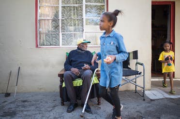 Fredie Blom (L) watches his wife's grandchildren run around as he celebrates his 116th birthday at his home in Delft, near Cape Town, on May 8, 2020. (AFP)