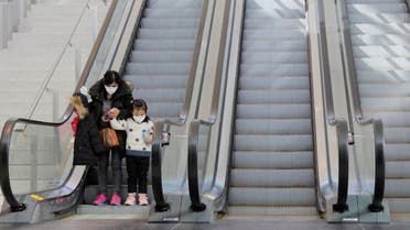 A woman and a child wear masks while on an escalator in John F Kennedy International Airport in New York, U.S., amid coronavirus reports on March 11, 2020. (Reuters)