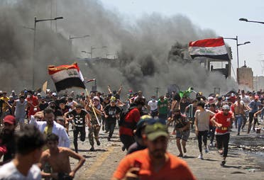 Iraqi protesters run for cover as they clash with security forces on Al-Jumhuriyah bridge in the capital Baghdad, during an anti-government demonstration on May 10, 2020. (AFP)