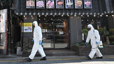 South Korean soldiers wearing protective gear spray disinfectant on the street to help prevent the spread of the COVID-19 coronavirus, at Gangnam district in Seoul. (AFP)
