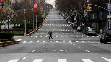 A woman crosses the empty of street Park Avenue in Manhattan as the outbreak of coronavirus disease (COVID-19) continues in New York. (AFP)