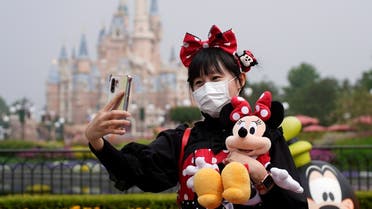 A visitor dressed as a Disney character takes a selfie while wearing a protective face mask at Shanghai Disney Resort as the Shanghai Disneyland theme park reopens following a shutdown due to the coronavirus disease (COVID-19) outbreak, in Shanghai, China May 11, 2020. (Reuters)