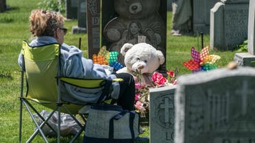 A woman visits her daughter’s grave at Calvary Cemetery on May 10, 2020 in the Queens borough of New York City. (AFP)
