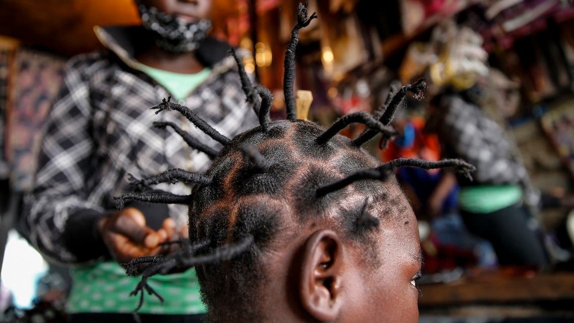 Gettrueth Ambio, 12, has her hair styled in the shape of the new coronavirus, at the Mama Brayo Beauty Salon in the Kibera slum, or informal settlement, of Nairobi, Kenya. (AP)