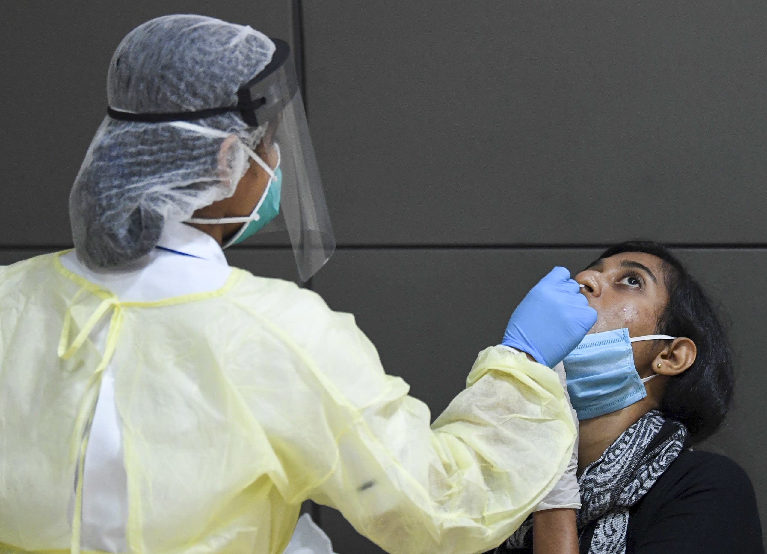 A member of an Indian medical team is tested upon the team's arrival at Dubai International Airport on May 9, 2020, to help with the coronavirus (COVID-19) pandemic. 
