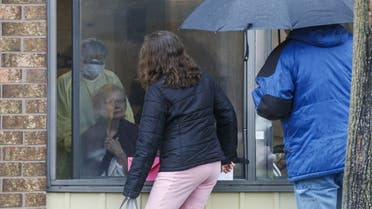 A family has a window visit with their mother at the Orchard Villa Retirement Centre one of the hardest hit by the coronavirus pandemic on Mother's Day, May 10, 2020 in Pickering, Canada. (AFP)