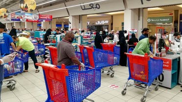 Customers queue to pay for groceries at a supermarket during a nationwide curfew to stem the spread of COVID-19 in the Saudi capital Riyadh. (AFP)