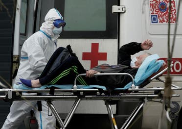 A medical specialist wearing protective gear transports a man on a stretcher outside a hospital for patients infected with the coronavirus on the outskirts of Moscow, Russia, April 29, 2020. (Reuters)