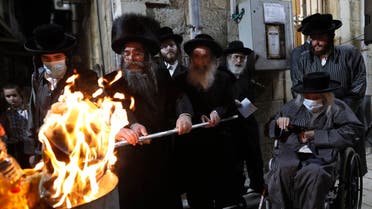 Ultra-Orthodox Jews light a Lag BaOmer bonfire in Jerusalem’s religious Mea Shearim neighbourhood amid an Israeli health ministry’s order to maintain social distancing and to cancel all Lag BaOmer holiday celebrations, on May 11, 2020, during the COVID-19 coronavirus pandemic. (AFP)