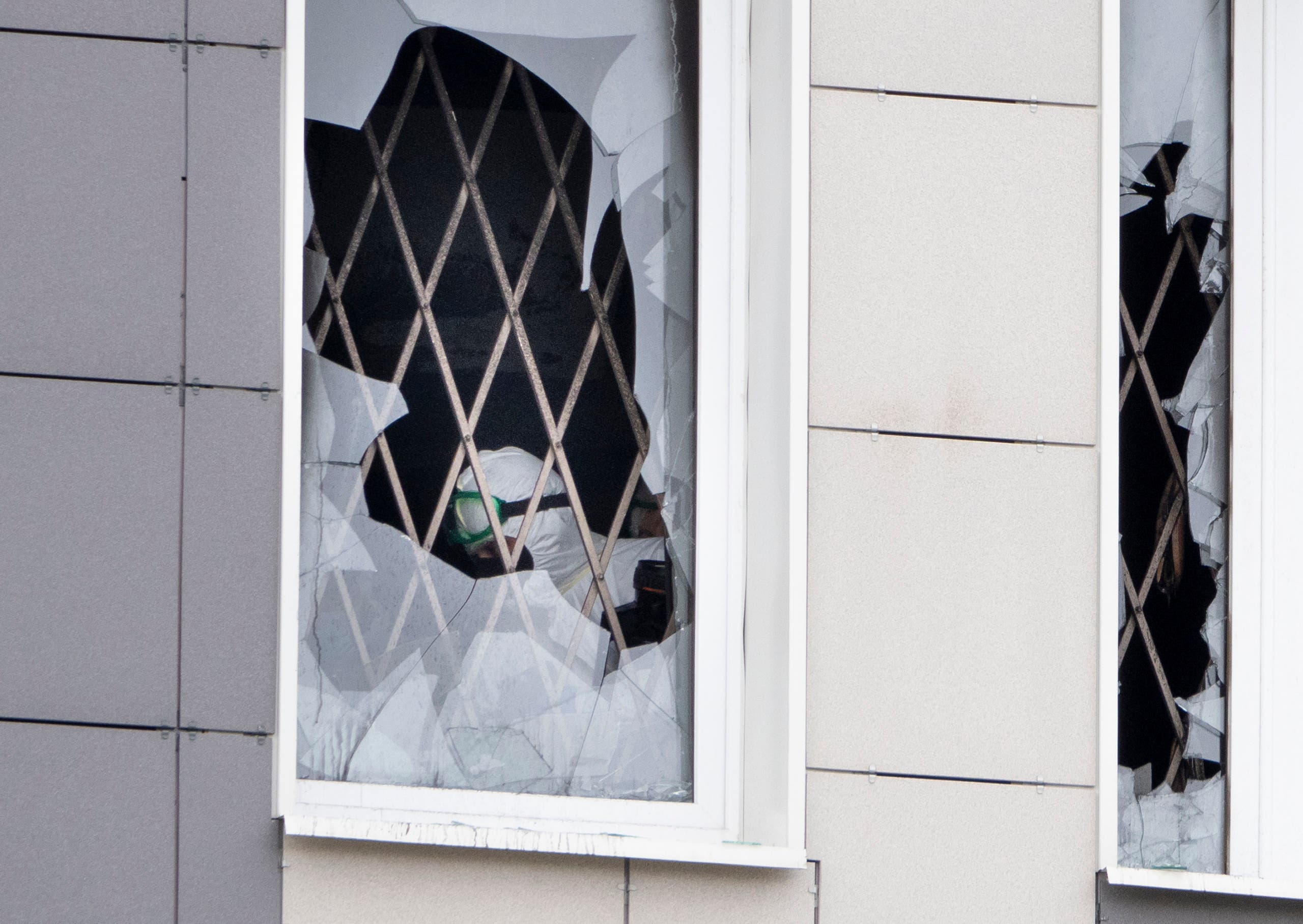 An investigator is seen through a broken window at the scene of a fire at St. George Hospital in St. Petersburg, Russia. (AP)