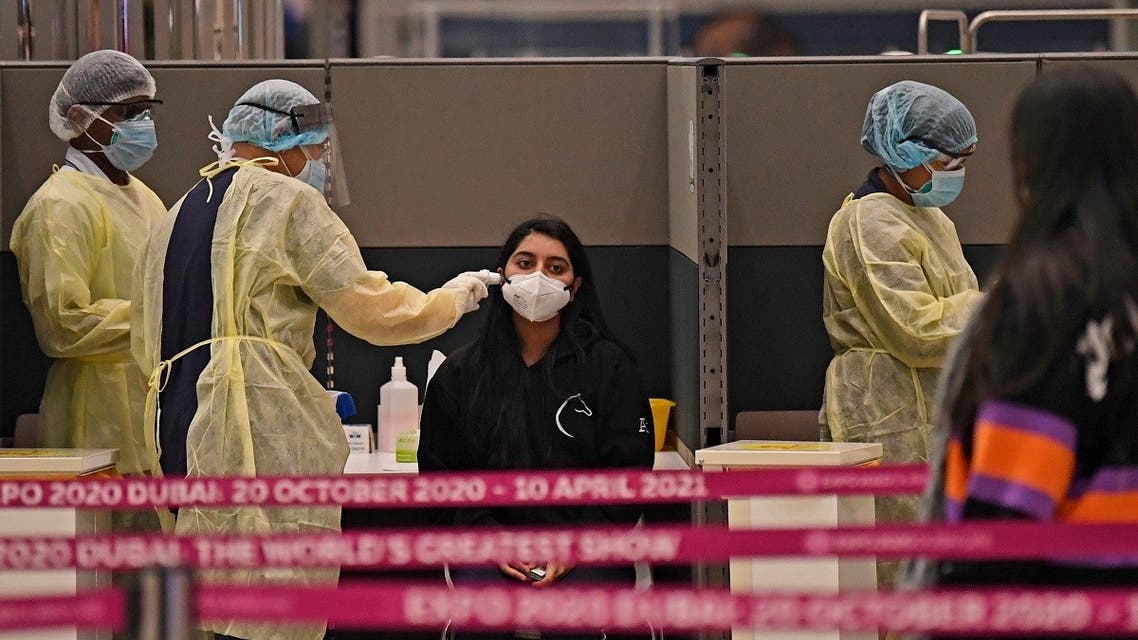 Health workers check passengers who arrived in an Emirates Airlines flight from London at Dubai International Airport on May 8, 2020 amid the coronavirus Covid-19 pandemic. (AFP)