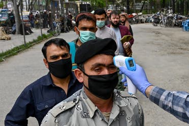 In this file photo taken on April 24, 2020 a health worker (R) checks the body temperature of a devotee before the Friday prayers on the first day of the Muslim holy month of Ramadan at Wazir Akbar Khan mosque in Kabul. (AFP)