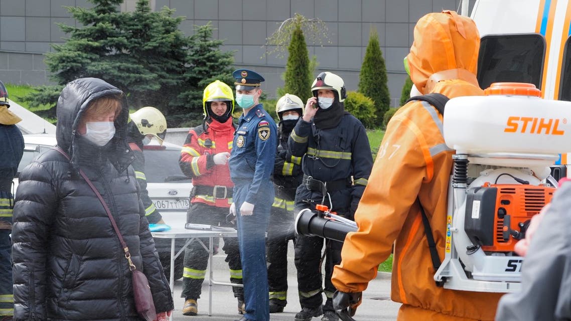A Russian Emergency Situation worker disinfects a woman near the scene of a fire at St. George Hospital in St. Petersburg, Russia. (AP)