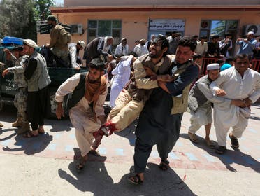 Men carry an injured person to a hospital after a blast during a funeral ceremony in Jalalabad, Afghanistan May 12, 2020.  (Reuters) 