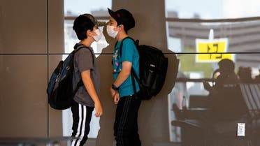 Kids play while wearing protective face masks at the Phoenix International Airport on March 14, 2020 in Phoenix, Arizona. (AFP)