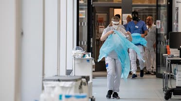 Healthcare workers put on protective gear as they prepare to receive a patient at the Intensive Care Unit at a hospital near Stockholm on May 13, 2020, during the coronavirus pandemic. (AFP)