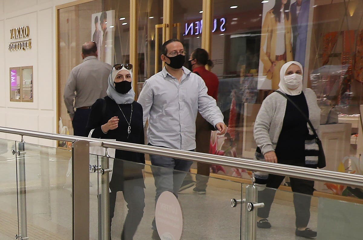 People wearing protective face masks walk inside a shopping mall on May 11, 2020 in Ankara, on the first day of reopening of shops which has been closed since March 21 due to the coronavirus. (AFP)