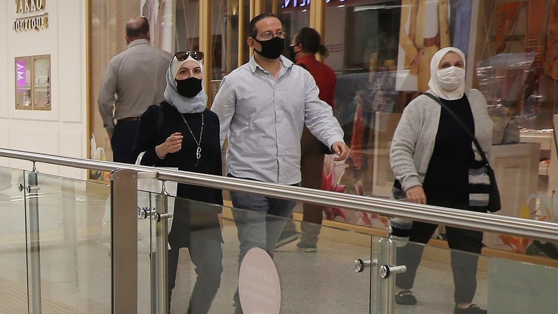 People wearing protective face masks walk inside a shopping mall on May 11, 2020 in Ankara, on the first day of reopening of shops which has been closed since March 21 due to the coronavirus. (AFP)
