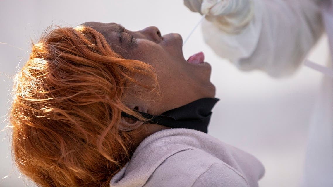 A woman opens her mouth for a heath worker to collect a sample for coronavirus testing during the screening and testing campaign aimed to combat the spread of COVID-19 at Alexandra township in Johannesburg, South Africa. (Reuters)