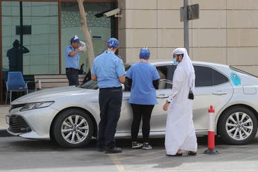 Health workers assist at a drive-thru testing service for COVID-19 coronavirus in the Qatari capital Doha, on May 7, 2020. (AFP)