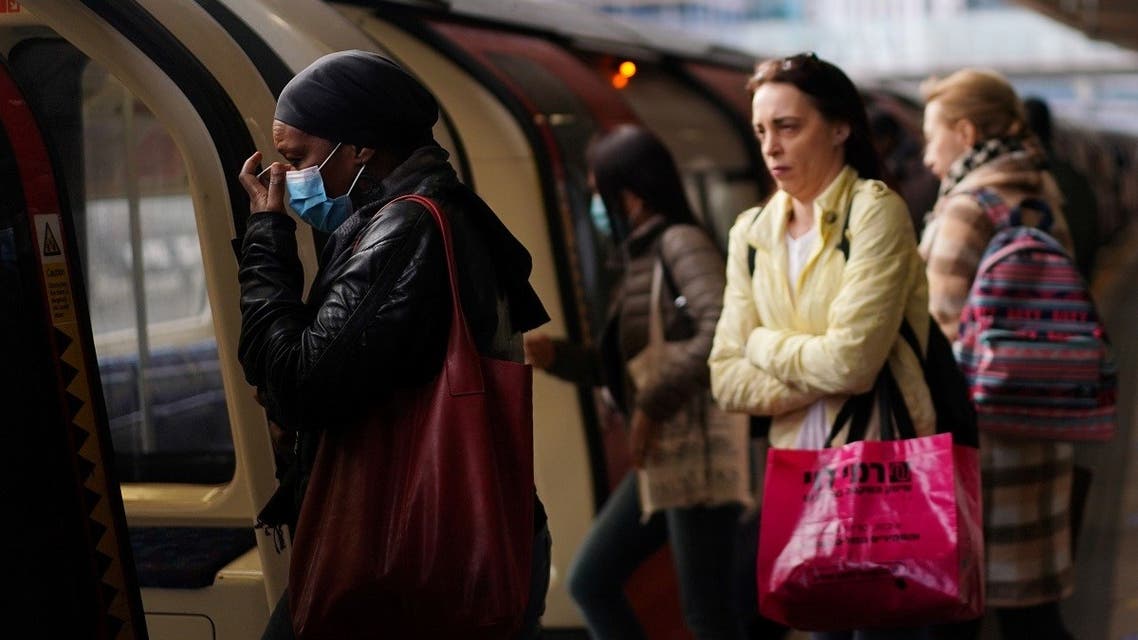 Commuters, some wearing masks are seen at a London Underground station. (Reuters)