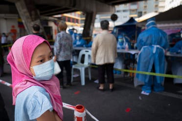 A Muslim girl wearing a face mask waits for new coronavirus testing at a wet market in Kuala Lumpur, Malaysia May 5, 2020. (AP)