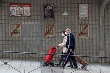 A couple walk past the closed stadium of Spanish 2nd division club Rayo Vallecano in Madrid, Spain, on Thursday, May 14, 2020. (AP)