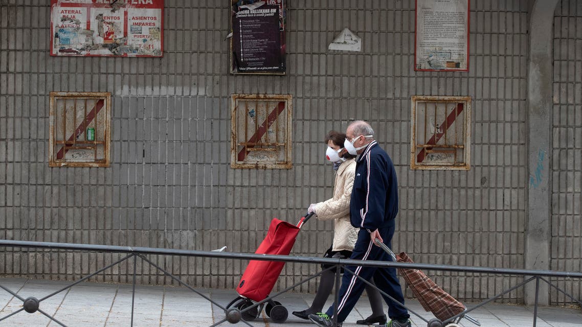 A couple walk past the closed stadium of Spanish 2nd division club Rayo Vallecano in Madrid, Spain, on Thursday, May 14, 2020. (AP)
