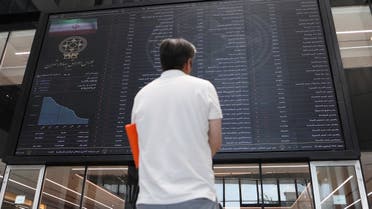 A man looks at electronic board showing stock prices, following the outbreak of the coronavirus disease at Tehran Stock Exchange in Tehran, Iran, May 12, 2020. (Reuters)