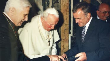 Pope Benedict XVI , left, shows documents to Pope John Paul II center, as Hubert Gschwendtner, mayor of Marktl, looks on in Marktl. (File Photo: AP)