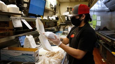 Matthew Sargosa places a sandwich in a takeout container at Dancing Tomato Caffe in Yuba City, Calif., Tuesday, May 12, 2020. (AP)