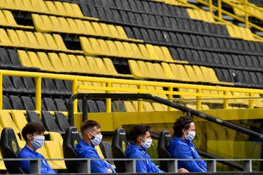 Schalke alternate players sit on the bench during the German Bundesliga football match between Borussia Dortmund and Schalke 04 in Dortmund, Germany, on Saturday, May 16, 2020. (AP)