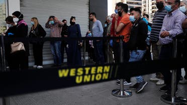Lebanese citizens queue outside a Western Union shop to receive their money transfer in US dollar currency, in Beirut on Thursday, April 23, 2020. (AP)
