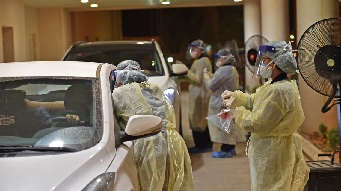 Health workers perform a nose swab test during a drive through coronavirus test campaign held in Diriyah hospital in the Saudi capital Riyadh on May 7, 2020. (AFP)