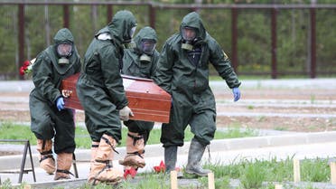 Grave diggers wearing protective suits carry a coffin during the burial of a coronavirus disease (COVID-19) victim at a cemetery on the outskirts of Moscow, Russia, May 15, 2020. (Moscow News Agency Handout via Reuters)