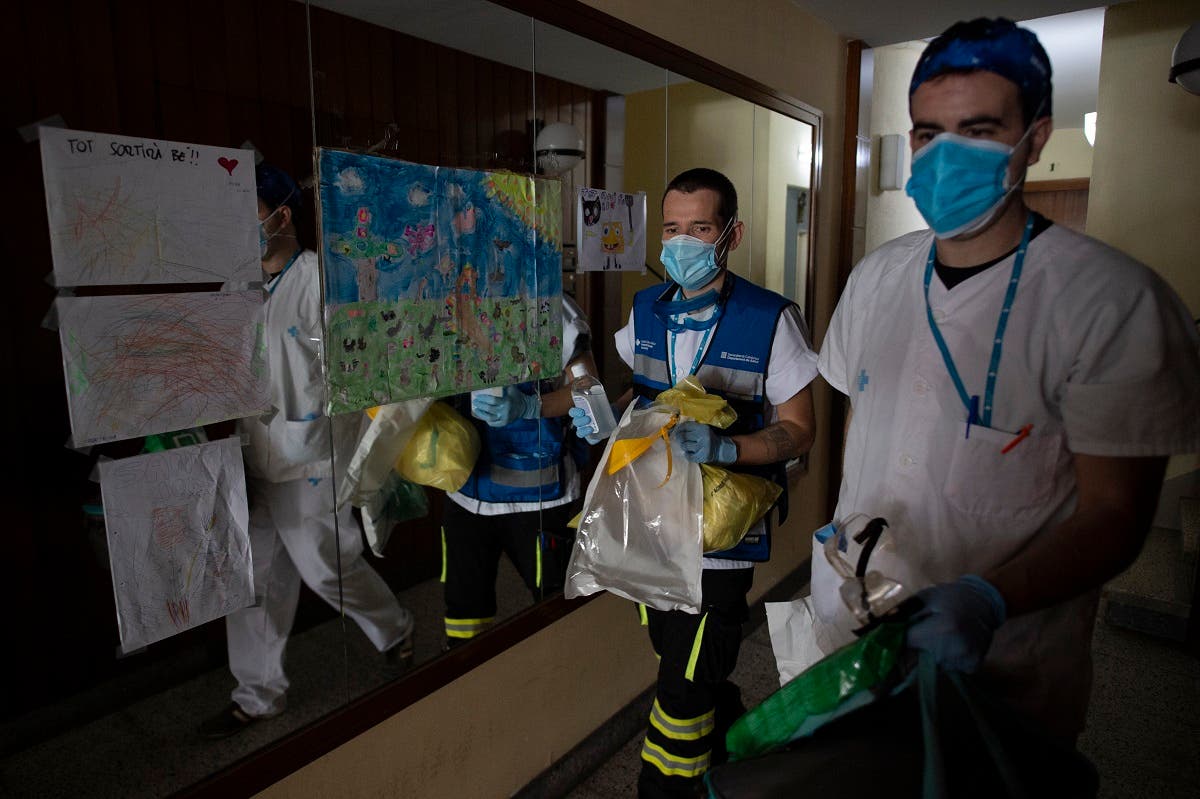 Healthcare workers leave after visiting patients at their homes in Barcelona on May 1, 2020. (AFP)