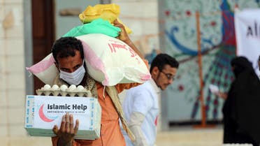 A man wearing a protective mask receives humanitarian aid in Yemen's third city of Taez, on May 8, 2020, amid the novel coronavirus pandemic crisis. (AFP)