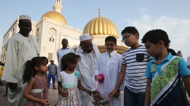 Muslim children distribute chocolates at the end of the morning Eid al-Adha prayer outside a mosque in the Omani capital Muscat on September 12, 2016. (AFP)