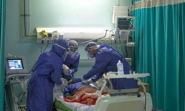 A picture taken by a doctor at the Sheikh Zayed hospital in the Egyptian capital Cairo on April 25, 2020, shows members of a medical staff, wearing protective gear, intubating a patient in the isolated ward for the coronavirus (COVID-19) patients. (AFP)