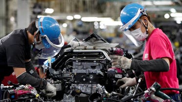 Employees wearing protective face masks and face guards work on the automobile assembly line as the maker ramps up car production with new security and health measures as a step to resume full operations, during the outbreak of the coronavirus disease (COVID-19), at Kawasaki factory of Mitsubishi Fuso Truck and Bus Corp., owned by Germany-based Daimler AG, in Kawasaki, south of Tokyo, Japan May 18, 2020. REUTERS/Issei Kato