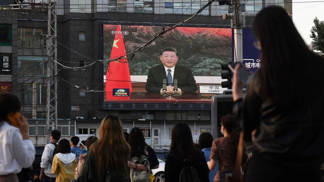 A news program shows Chinese President Xi Jinping speaking via video link to the World Health Assembly, on a giant screen beside a street in Beijing on May 18, 2020. (AFP)