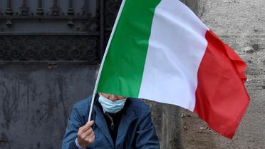 A man holds a flag as he takes part in a protest in front of the Alla Scala theatre, as Italy eases some of the lockdown measures put in place during the coronavirus disease (COVID-19) outbreak, in Milan, Italy May 18, 2020. REUTERS/Flavio Lo Scalzo