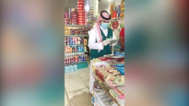 A Ministry of Commerce employee inspects a grocery store. (SPA) 