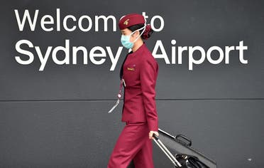 A Qatar Airways crew member enters Sydney international airport to fly on a repatriation flight back to France on April 2, amid the coronavirus pandemic. (AFP)