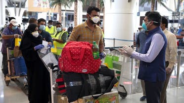 Indian nationals check in at the Muscat International Airport before leaving the Omani capital on a flight to return to their country, on May 9, 2020. (AFP)